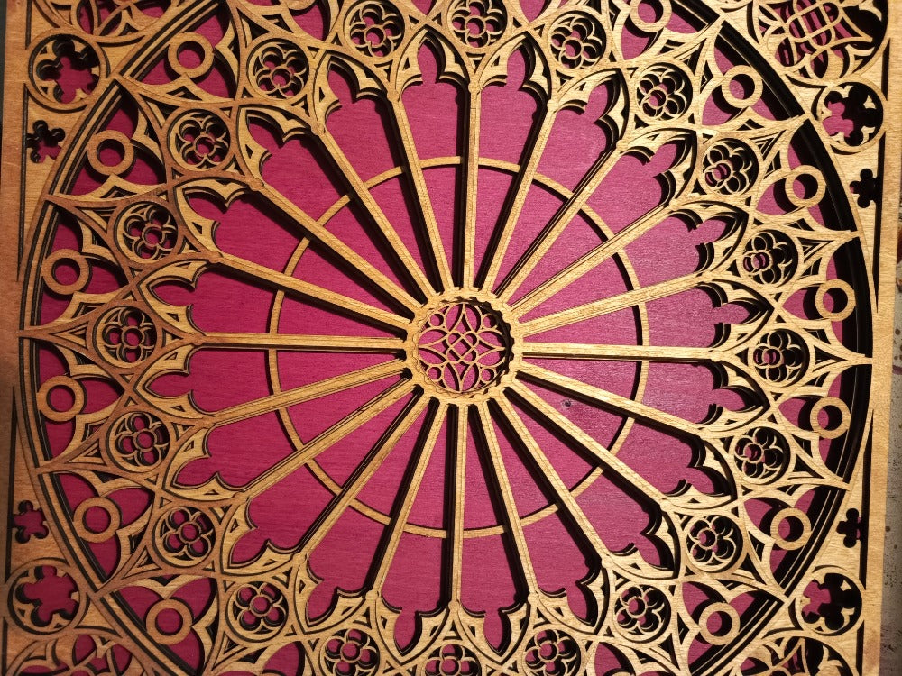 Decorative wooden panel with intricate cut-out patterns on a pink background